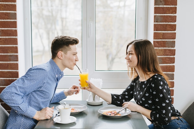 Foto gratuita coppia con un succo d'arancia in un ristorante