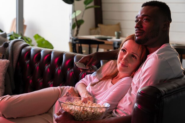 Couple having some popcorn while watching a movie