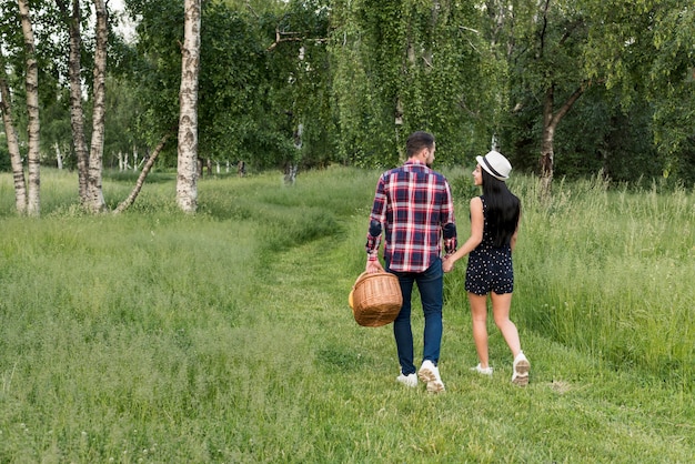 Couple having a walk holding a picnic basket