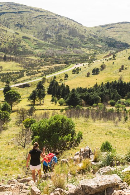 Couple hiking on stone hill near valley