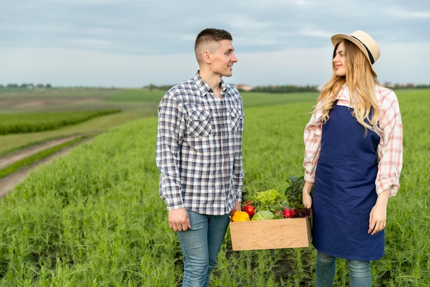 Couple holding basket of vegetables