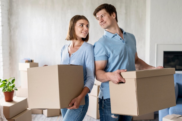 Couple holding boxes for moving out day