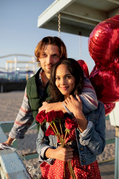 Couple holding a bunch of heart-shaped balloons while being on a date