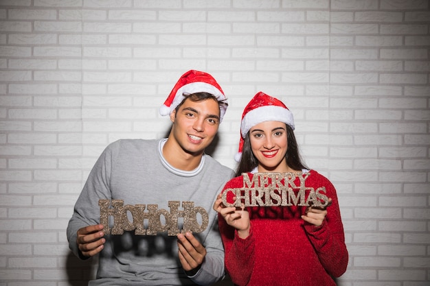 Couple holding Christmas inscriptions 