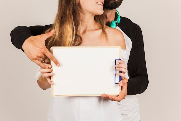 Couple holding clipboard horizontally