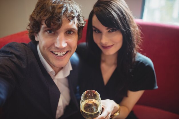 Couple holding drink and taking a selfie