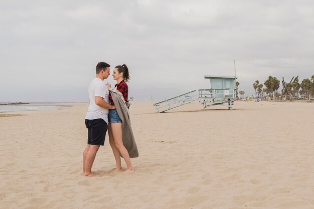 Couple holding each other on beach and posing