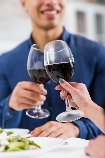 Couple holding glasses of red wine on valentine's day