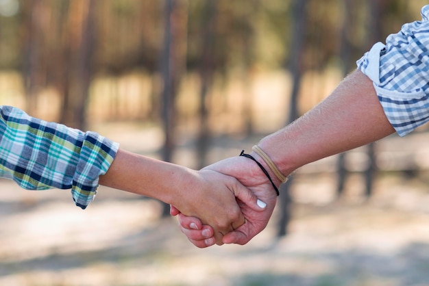 Free photo couple holding hands blurred nature