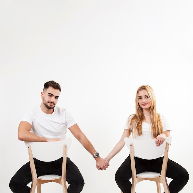 Free photo couple holding hands and looking at camera