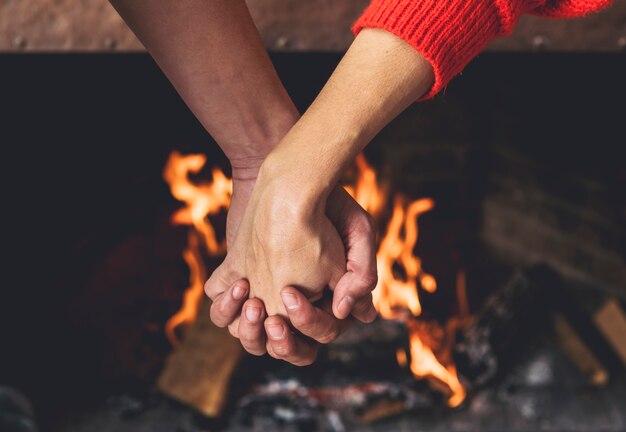 Couple holding hands near fireplace 