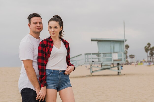 Couple holding hands posing on beach