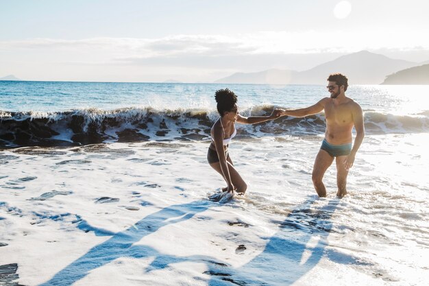 Couple holding hands in the water at the beach