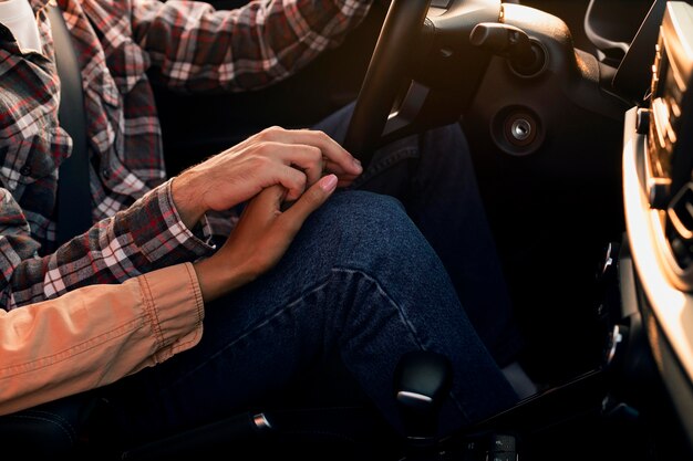 Couple holding hands while driving