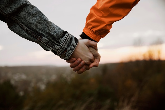 Couple holding hands while on a road trip together