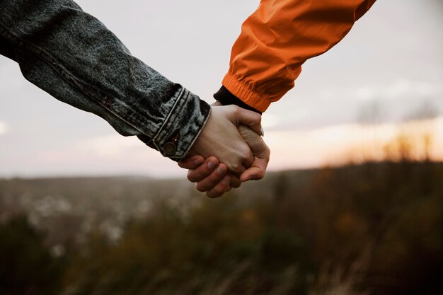 Couple holding hands while on a road trip together