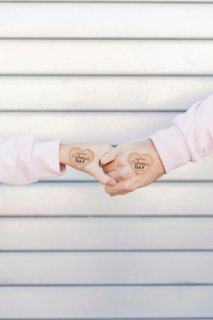 Couple holding hands with decorative symbols of heart