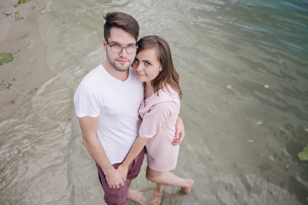 Couple holding hands with feet in water