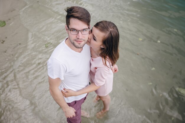 Couple holding hands with feet in water