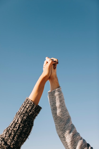 Couple holding hands with sky in background