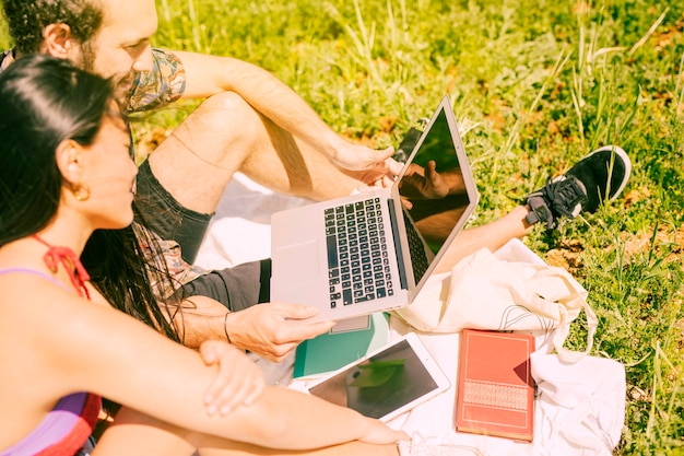 Free photo couple holding laptop in glade