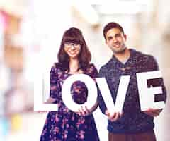 Free photo couple holding letters that says 