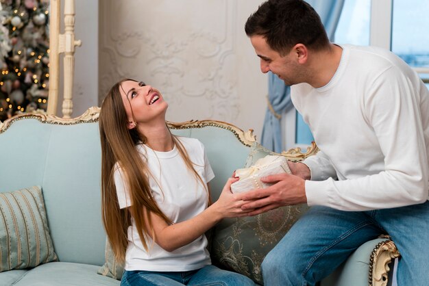 Couple holding present on sofa