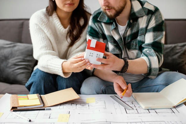 Couple holding small house close up