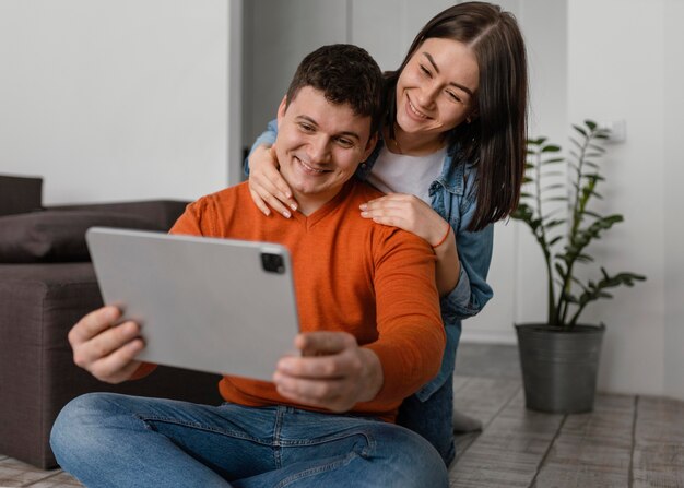 Couple holding tablet medium shot