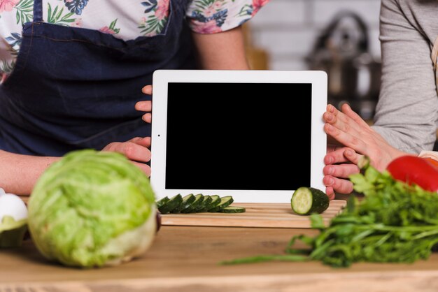 Couple holding tablet with screen to camera