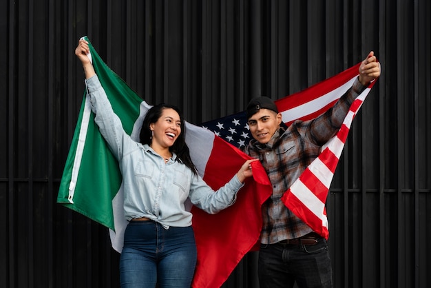 Free photo couple holding usa and mexico flags