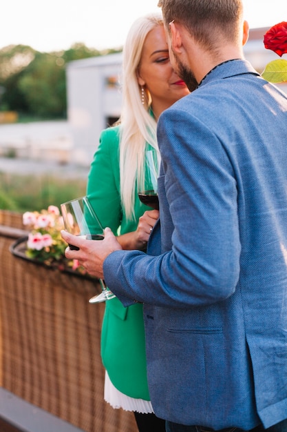 Couple holding wine glasses kissing each other at outdoors