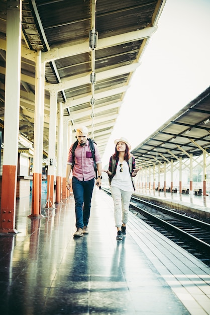 Coppia concetto di vacanza: giovane coppia hipster in stazione ferroviaria.