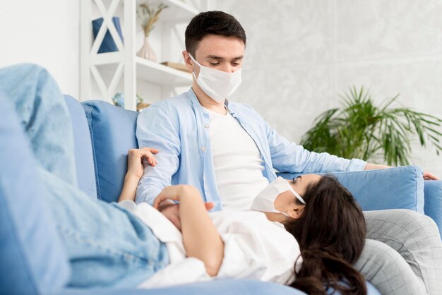 Couple at home on couch with medical masks