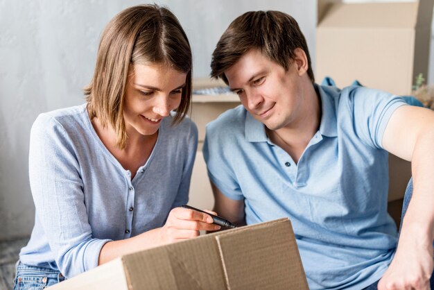 Couple at home on moving day labeling box