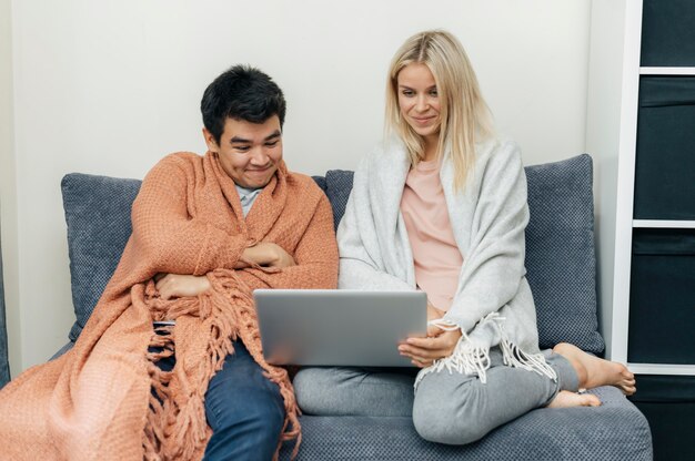 Couple at home together using laptop