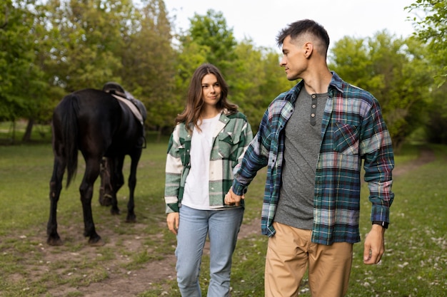 Couple and horse outdoors medium shot