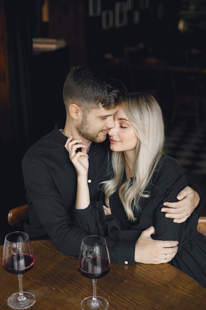 Free photo couple hugging and have wine in cafe