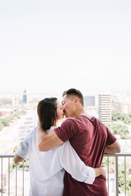 Couple hugging and kissing on balcony 