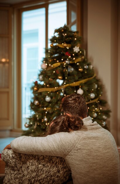 クリスマスツリーの近くの抱擁のカップル