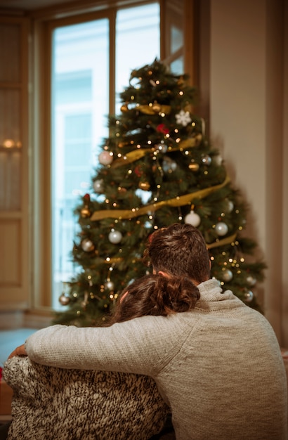 Couple hugging near Christmas tree