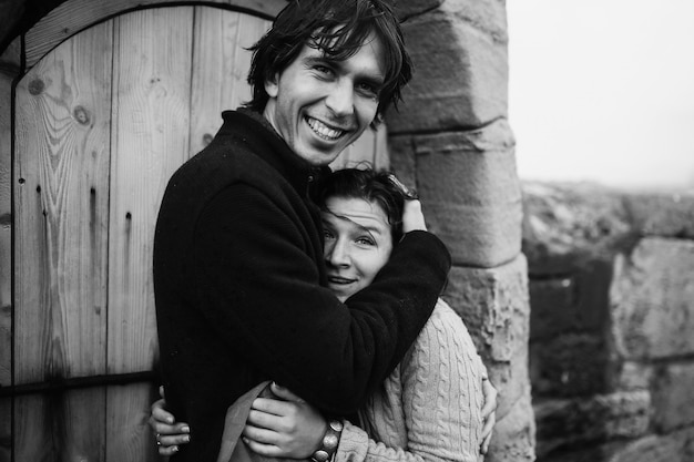 Couple hugging stands near the lighthouse door