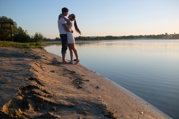 湖の背景と抱き合うカップル