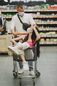 スーパーマーケット​の​カップル​。​医療​マスク​の​女性​。​人々​は​parchases​を​作ります​。