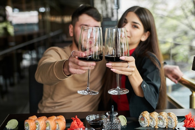 ワインを飲む寿司レストランのカップル。 Premium写真