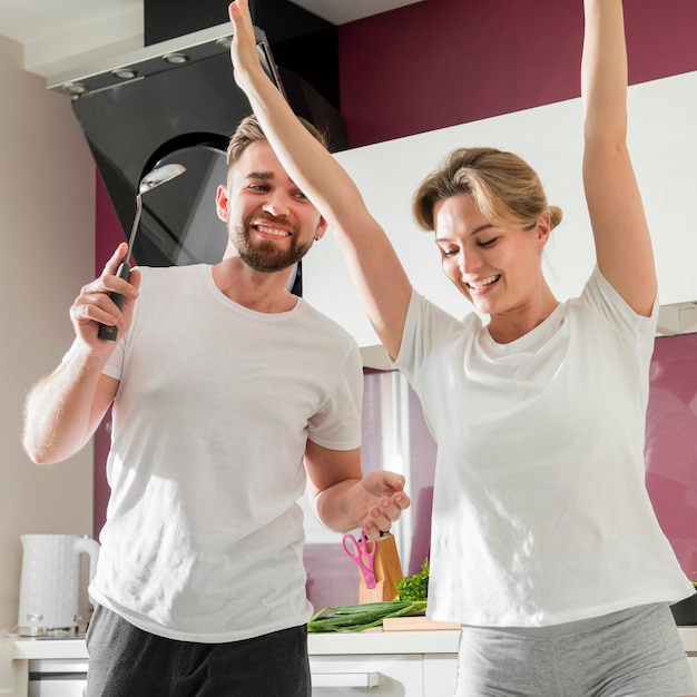 Free photo couple indoors dancing in the kitchen together