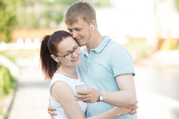 A couple is listening to music on the phone