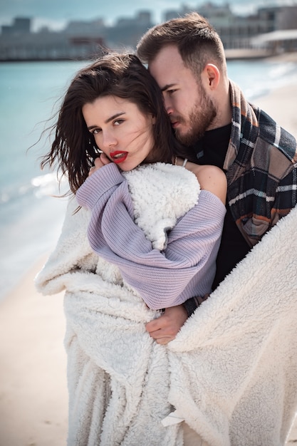 Free photo couple is standing on the beach and posing