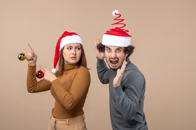 Una coppia è in piedi accanto all'albero di natale