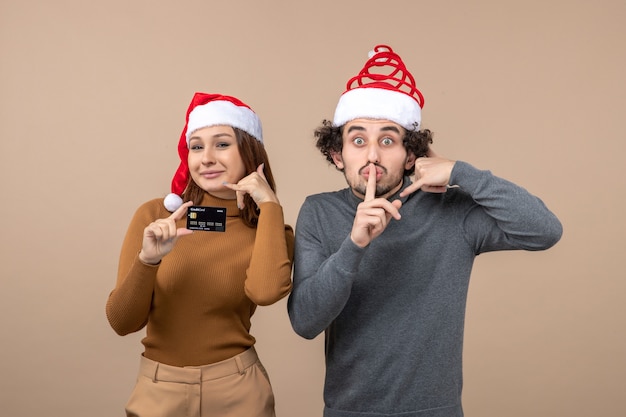 A couple is standing next to the Christmas tree